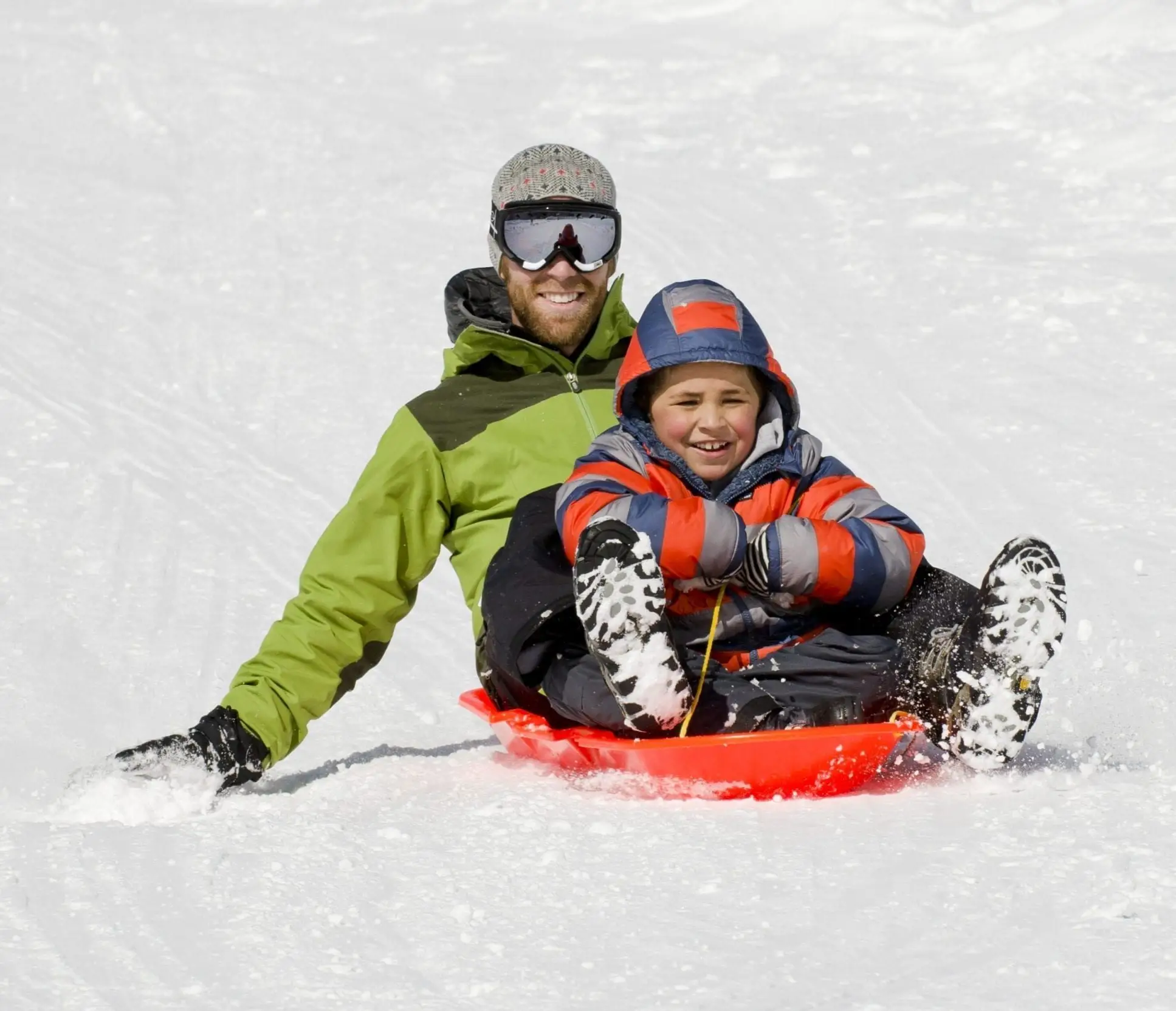 Father and snow sledding in Lake Tahoe smiling